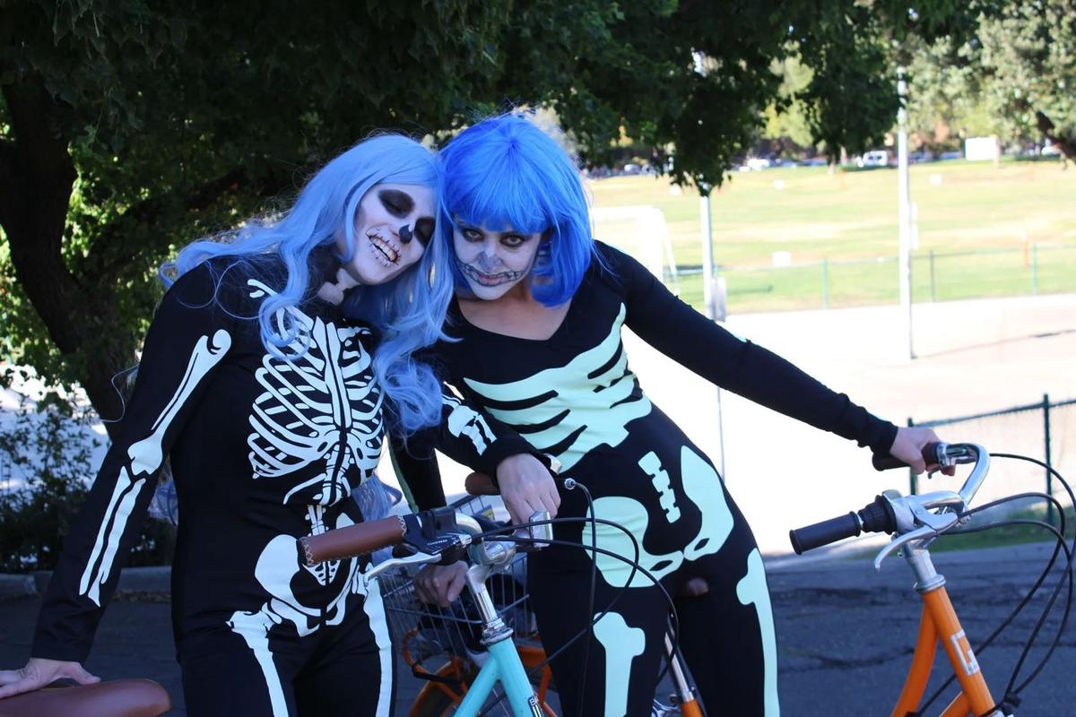 Two riders in blue wigs and skeleton face paint